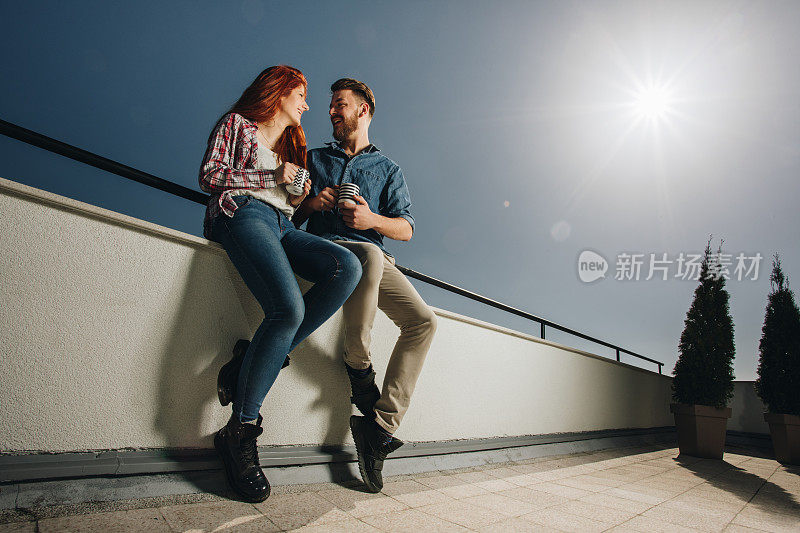 下面是一对幸福的夫妇在喝咖啡的时候在阳台上聊天。