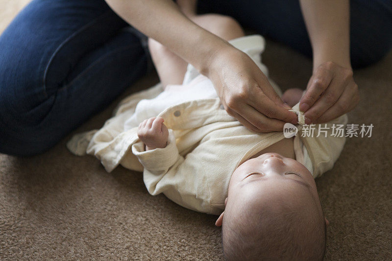 妈妈在给婴儿换衣服。