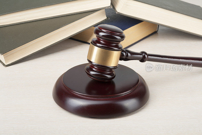 法律概念-在法庭或执行办公室的桌子上有法官木槌的书。