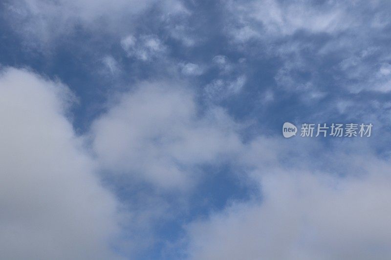 蓝色的天空中，蓬松、缕缕的白色积云