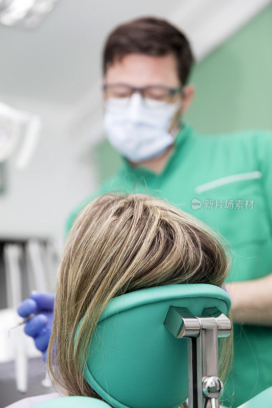 一位年轻女士正在牙科诊所接受牙科医生的牙齿检查