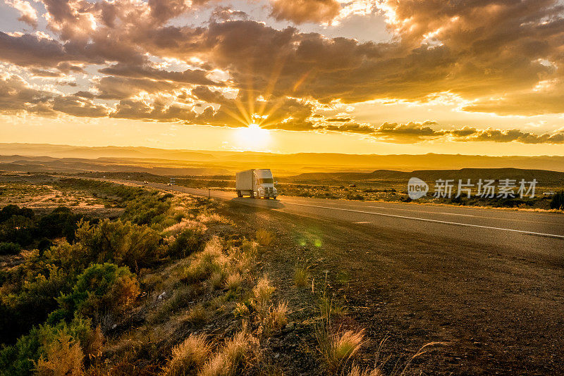 半卡车在州际公路黄昏与Cloudscape