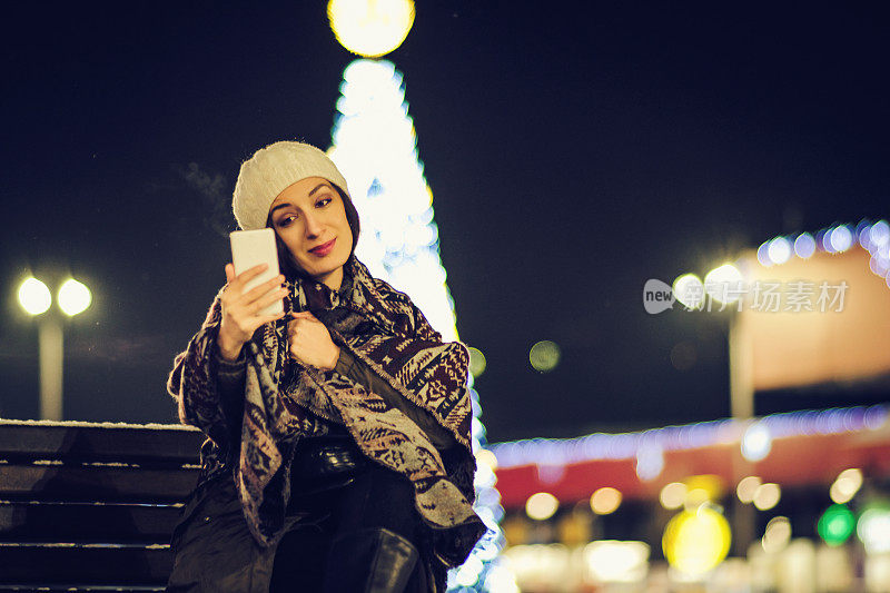 女人在街上用手机装饰圣诞节