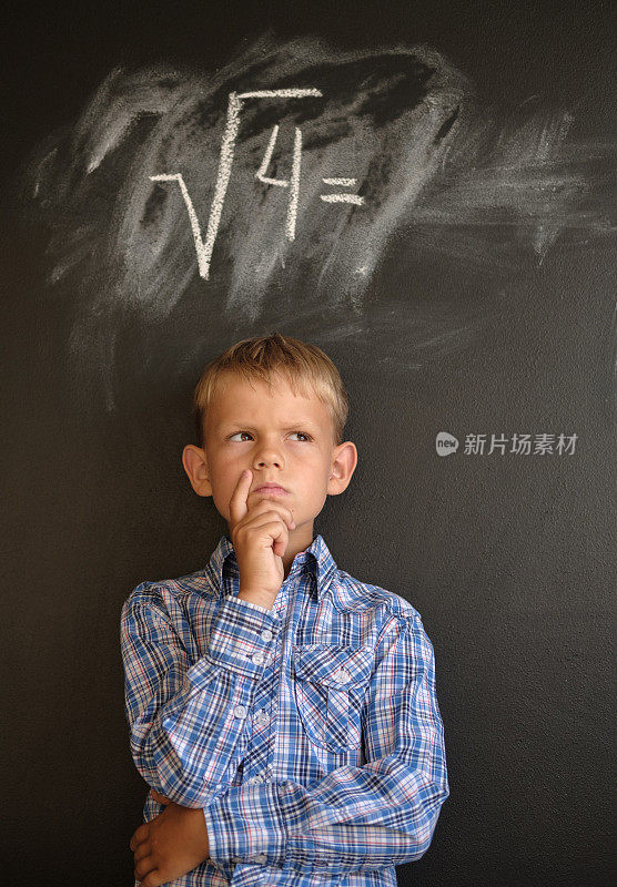 一个欧洲男孩站在黑板前想要解一道数学题