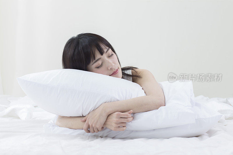 年轻女人抱着枕头睡觉