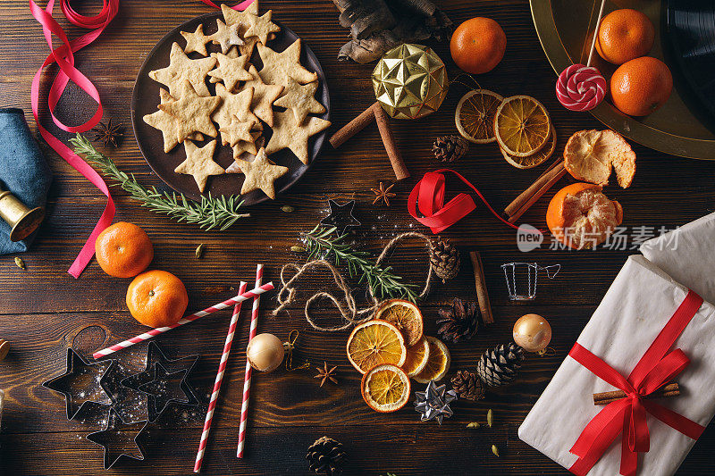 圣诞气息flatlay。顶视图。姜饼、橘子和木制背景的新年装饰品