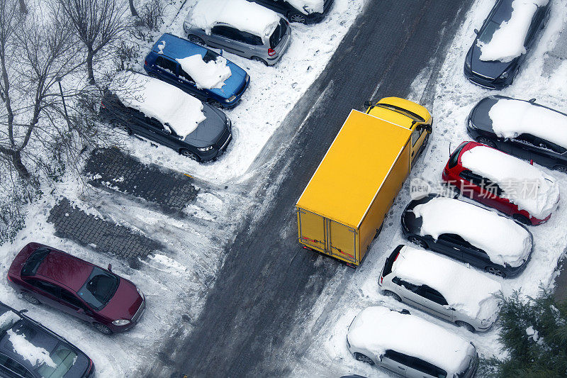 俯瞰结冰的城市街道上黄色的货车