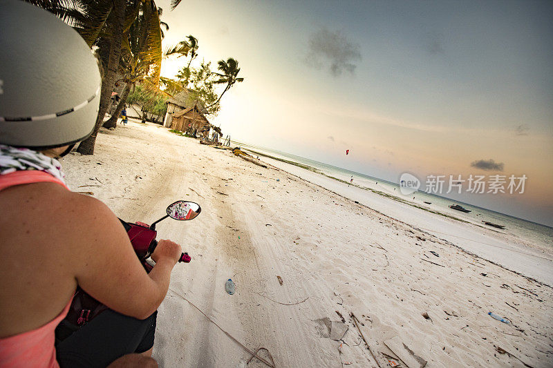 年轻女子探索一个热带岛屿的海滩与摩托车