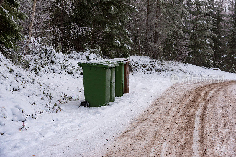 石子路边的垃圾桶堆在雪地里