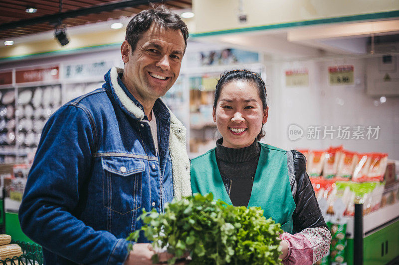 一名男子在超市和一名中国人摆姿势