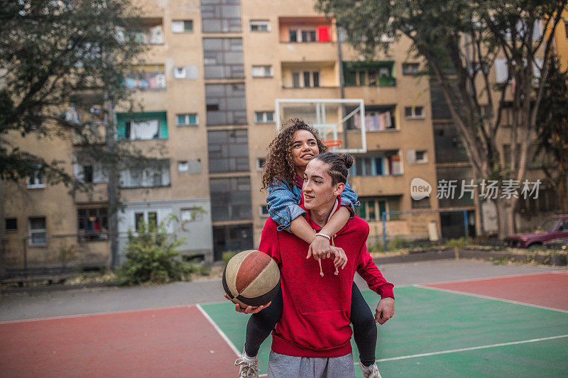 一对年轻情侣在篮球场