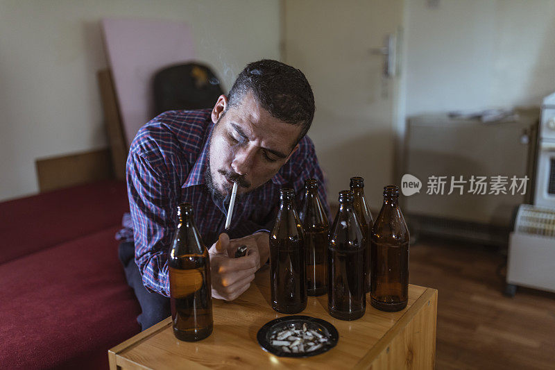 年轻悲伤的醉酒男子喝啤酒和酒精感到浪费，孤独和绝望的痛苦和情绪压力。人与酗酒、上瘾和男人抑郁的概念。