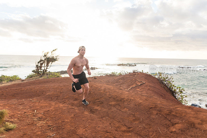 赤裸上身的慢跑者沿着夏威夷的海岸线跑步