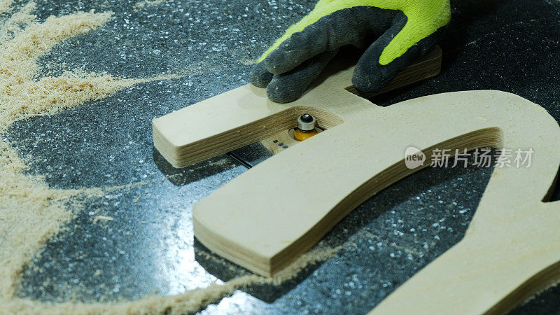 工人在家具厂拆除倒角半径切割机，特写。木制家具制造