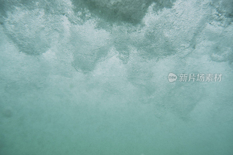 在海面下，头顶上的破浪带来了狂暴的气泡。