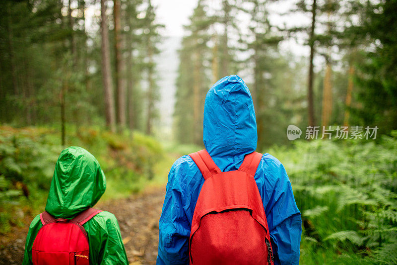 妈妈和女儿在雨中徒步旅行