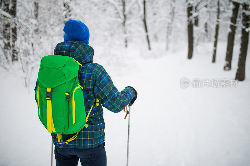 年轻人后视图独自行走雪山的旅行者。