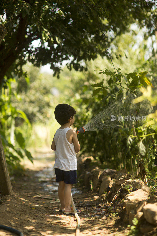 幼童在夏天在户外玩水管