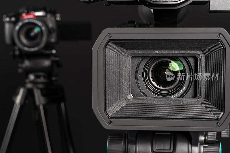 专业4K视频特写镜头和DSLR无反光镜三脚架在黑色工作室背景