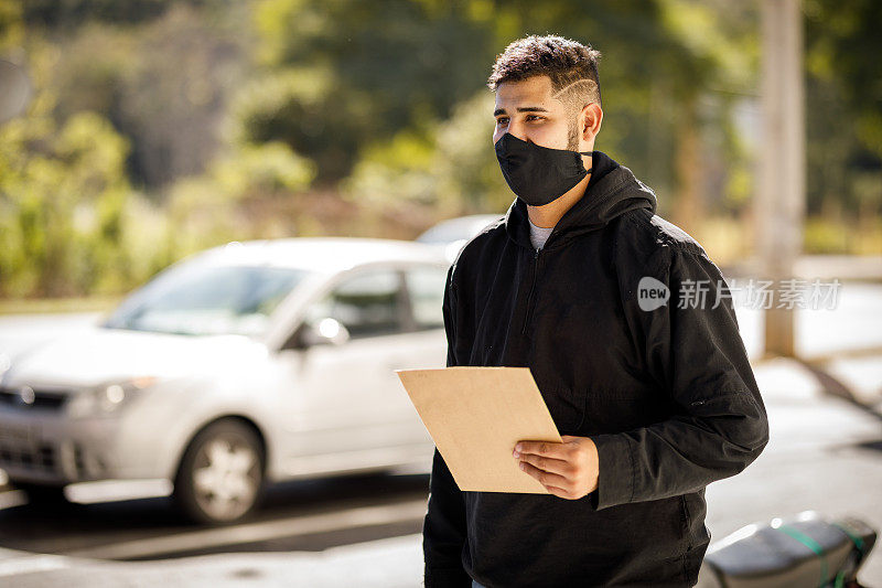 送货员带着防护面具送文件的摩托男孩