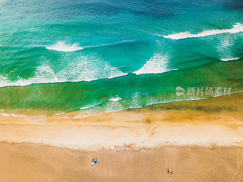 鸟瞰图的家庭休息在风景优美的遥远的海滩与大浪在挪威