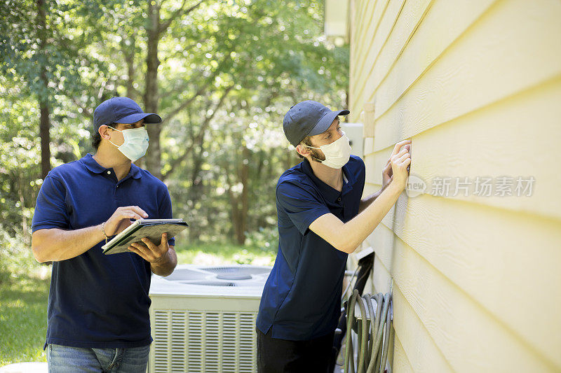 检查员或蓝领工人检查建筑墙壁。在户外。