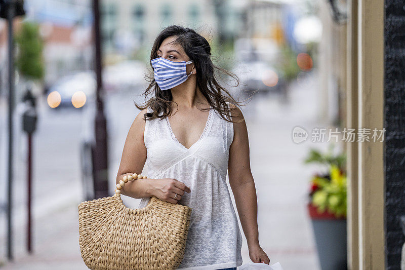 一名西班牙妇女戴着防护面具在市中心购物