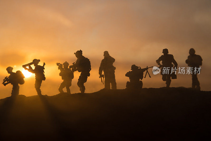 战争的概念。军事剪影战斗场景的战争雾天空的背景，世界大战士兵剪影下多云的天际线在日落。