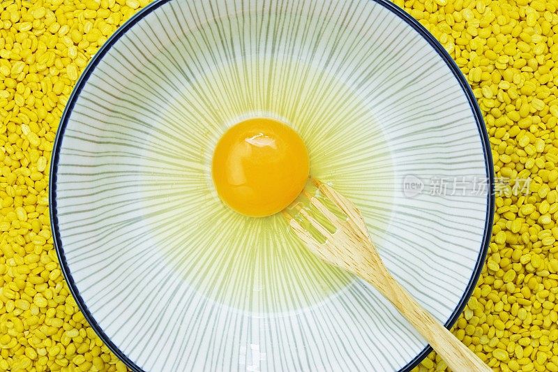 蛋清和蛋黄碗-黄色绿豆背景。