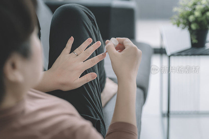 一位亚洲华人中年女性正在家里准备化妆指甲油