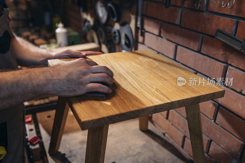 一个面目全非的工匠制作脚凳的手