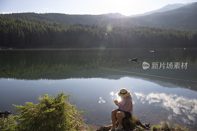 成熟的女人早晨在湖边放松