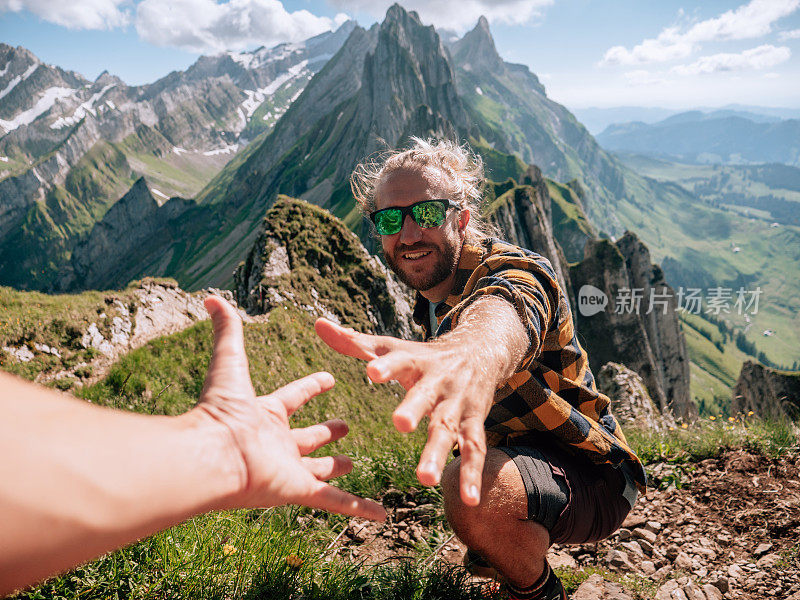 帮助队友攀登山脊岩石的徒步者