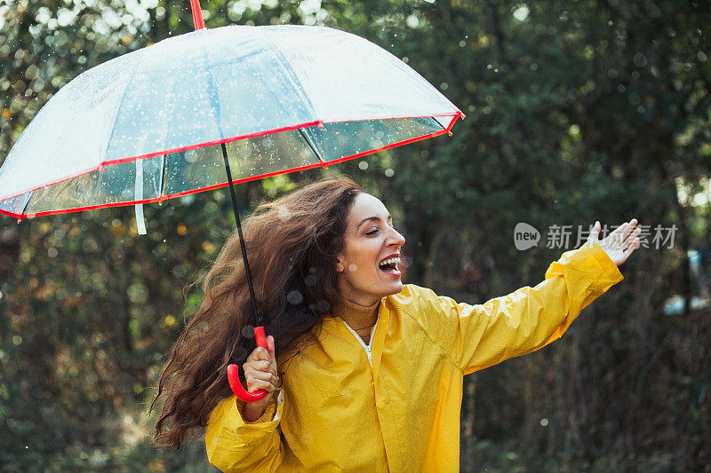 快乐的女人在雨中行走