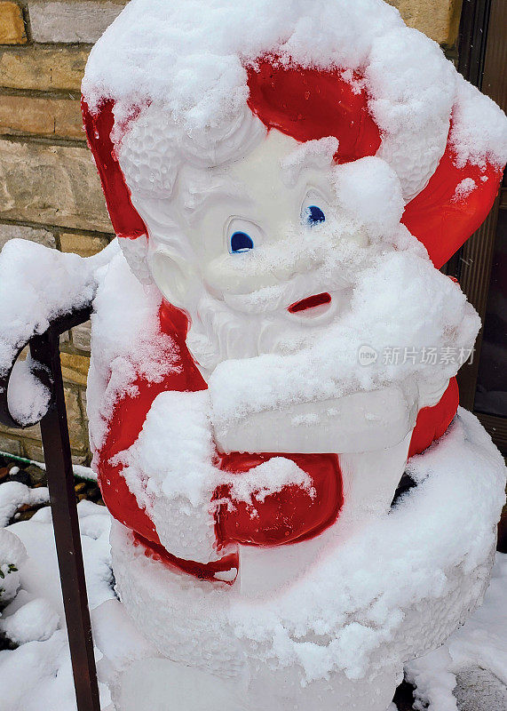 门阶上的大塑料圣诞老人浑身是雪