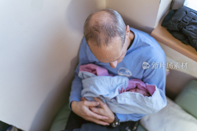 祖父第一次抱着孙子在病房里