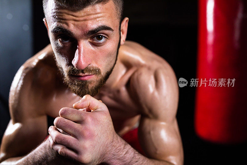 一个大汗淋漓的拳击手在沉重的背包锻炼后的肖像