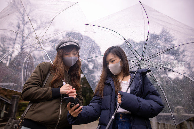 年轻女子戴着防护面罩在雨天自拍