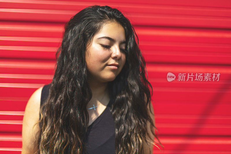 拉美裔美国原住民一代Z女性站在红色车库门前的城市照片系列