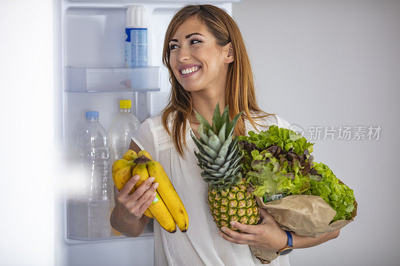 一个白人女人从冰箱里拿东西的侧视图。