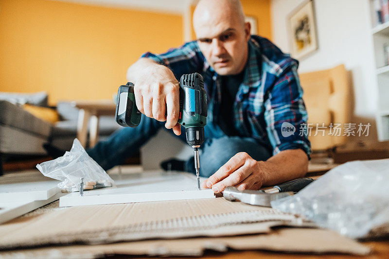 成熟的男人在家里组装家具