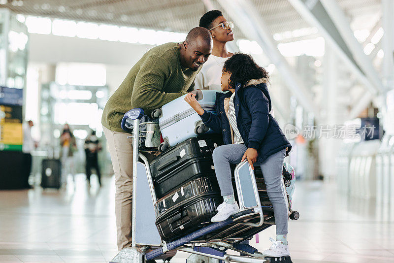 一个非洲家庭带着行李在机场等候