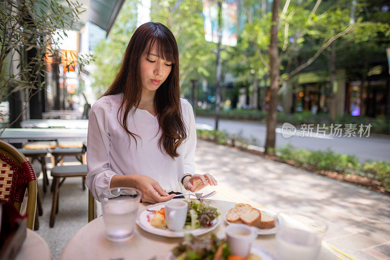 一名日本女子在露台咖啡馆吃午餐