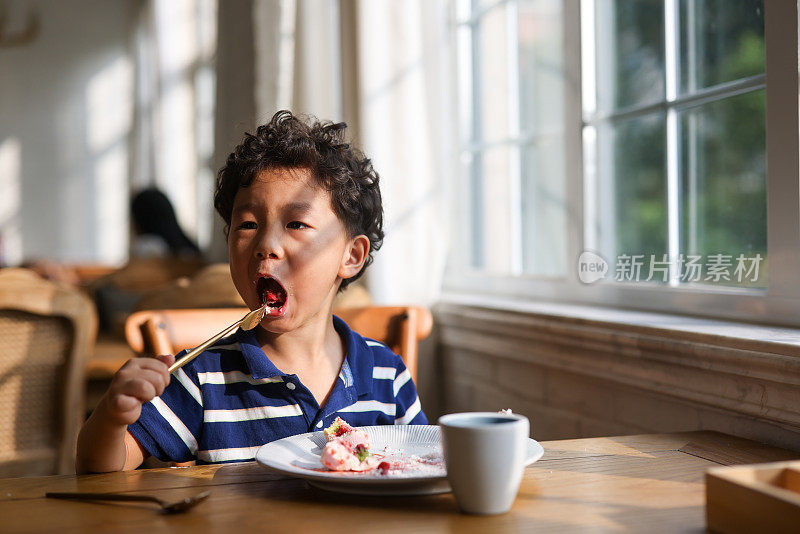 在餐馆吃甜点的小男孩