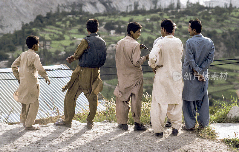 巴基斯坦男子在喀喇昆仑公路上穿着当地服装看着山谷