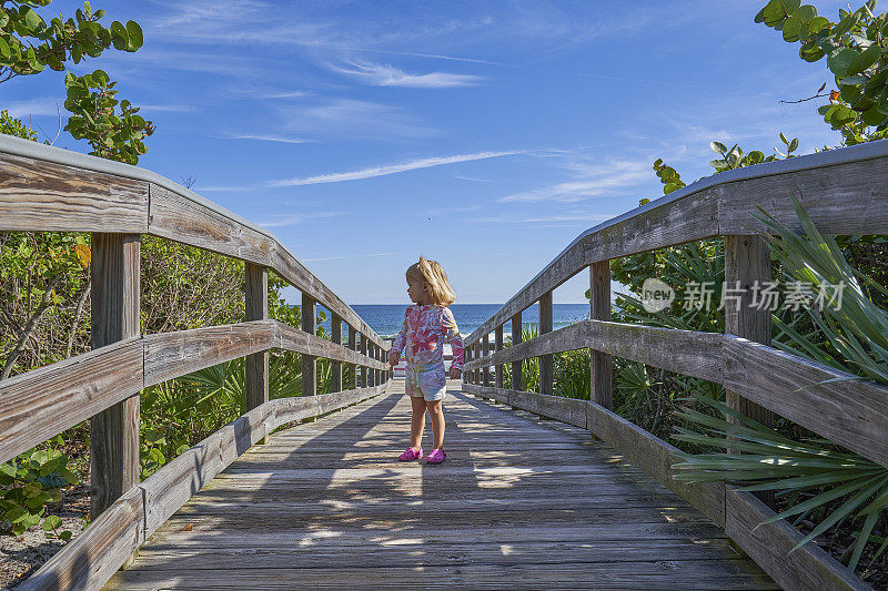 在佛罗里达州梅里特岛国家野生动物保护区附近的大西洋沿岸卡纳维拉尔国家海岸美丽的Playlinda海滩上玩耍的蹒跚学步的女孩
