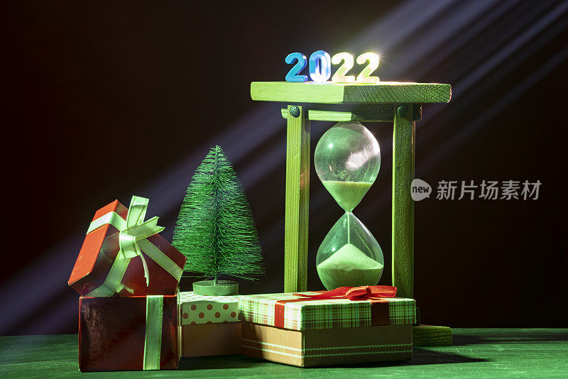 沙漏，礼盒和迷你圣诞树的照片与2022年新年数字