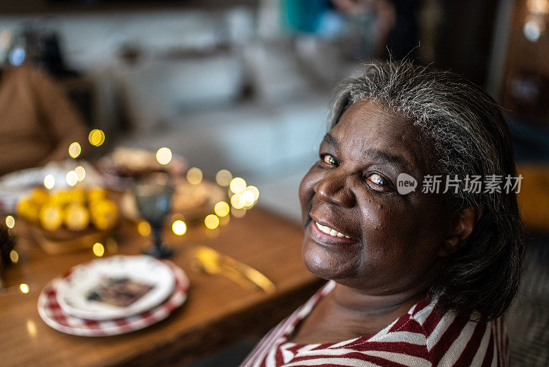 一个快乐的妇女的肖像在圣诞节午餐期间与家人在家里