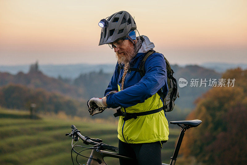 一个成年人在骑山地车的时候查看手表上的时间