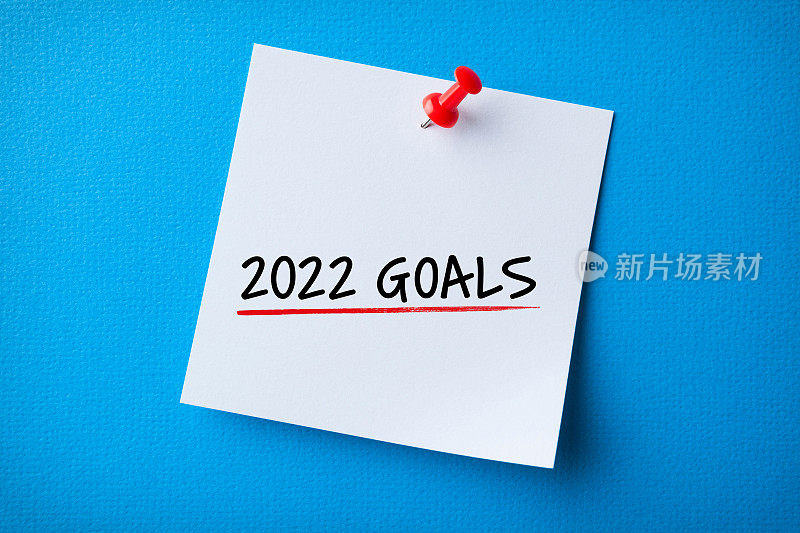 白色便利贴与新年2022年目标和红色图钉在蓝色背景